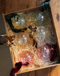 Set of six glass Christmas baubles with red green and gold swirl design