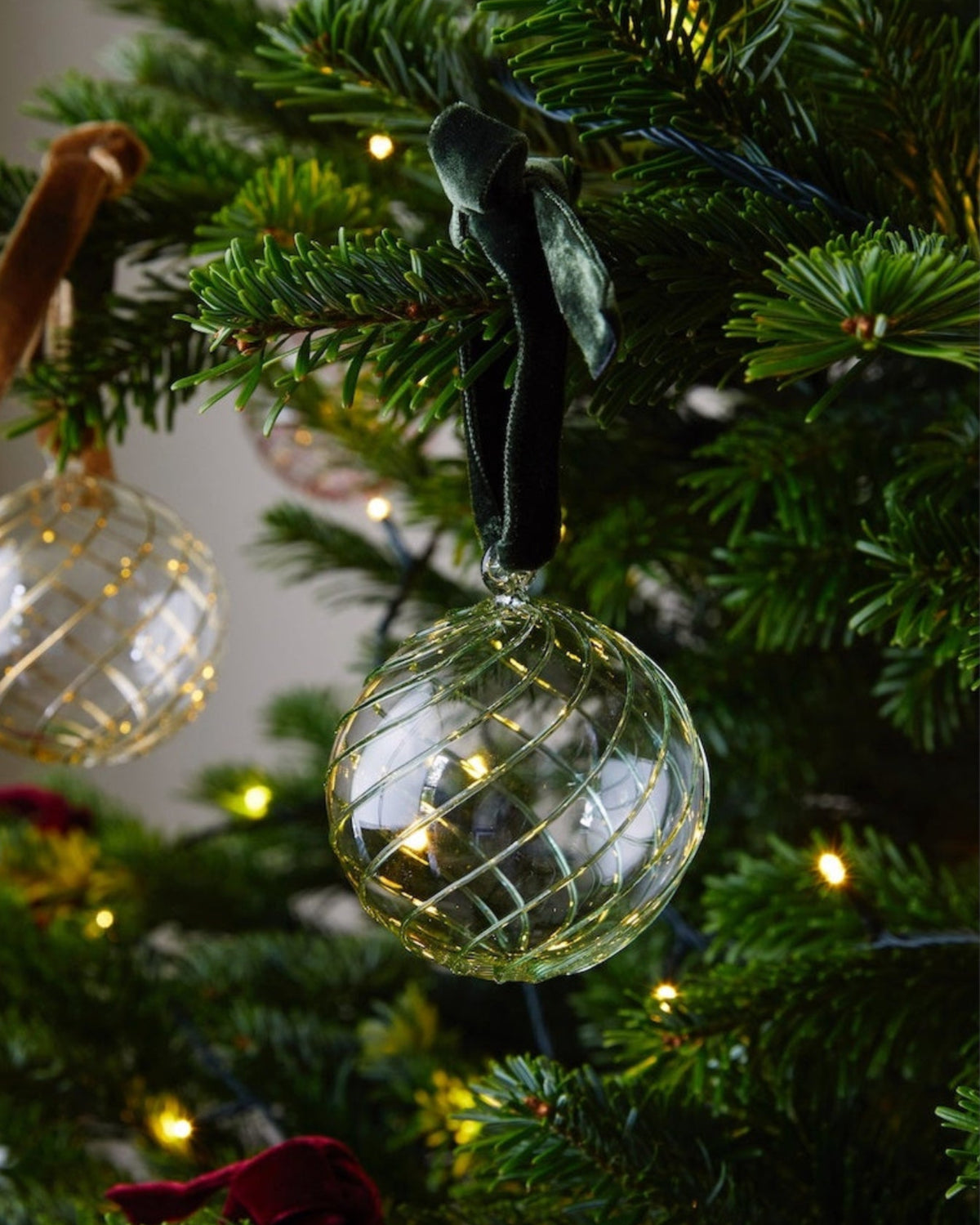 Close up of handblown glass Christmas bauble with green swirl pattern