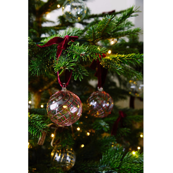 Close up of handblown glass Christmas bauble with red swirl pattern