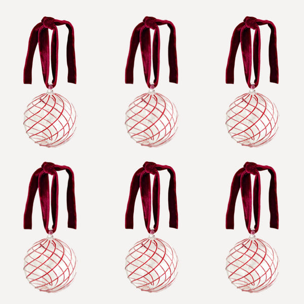 Set of six handblown glass Christmas baubles with red swirl design and velvet ribbon